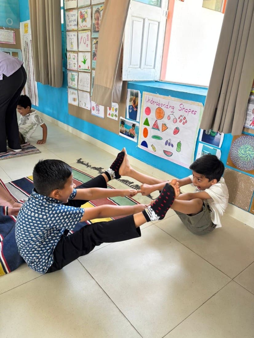 Children doing a partner stretch in class